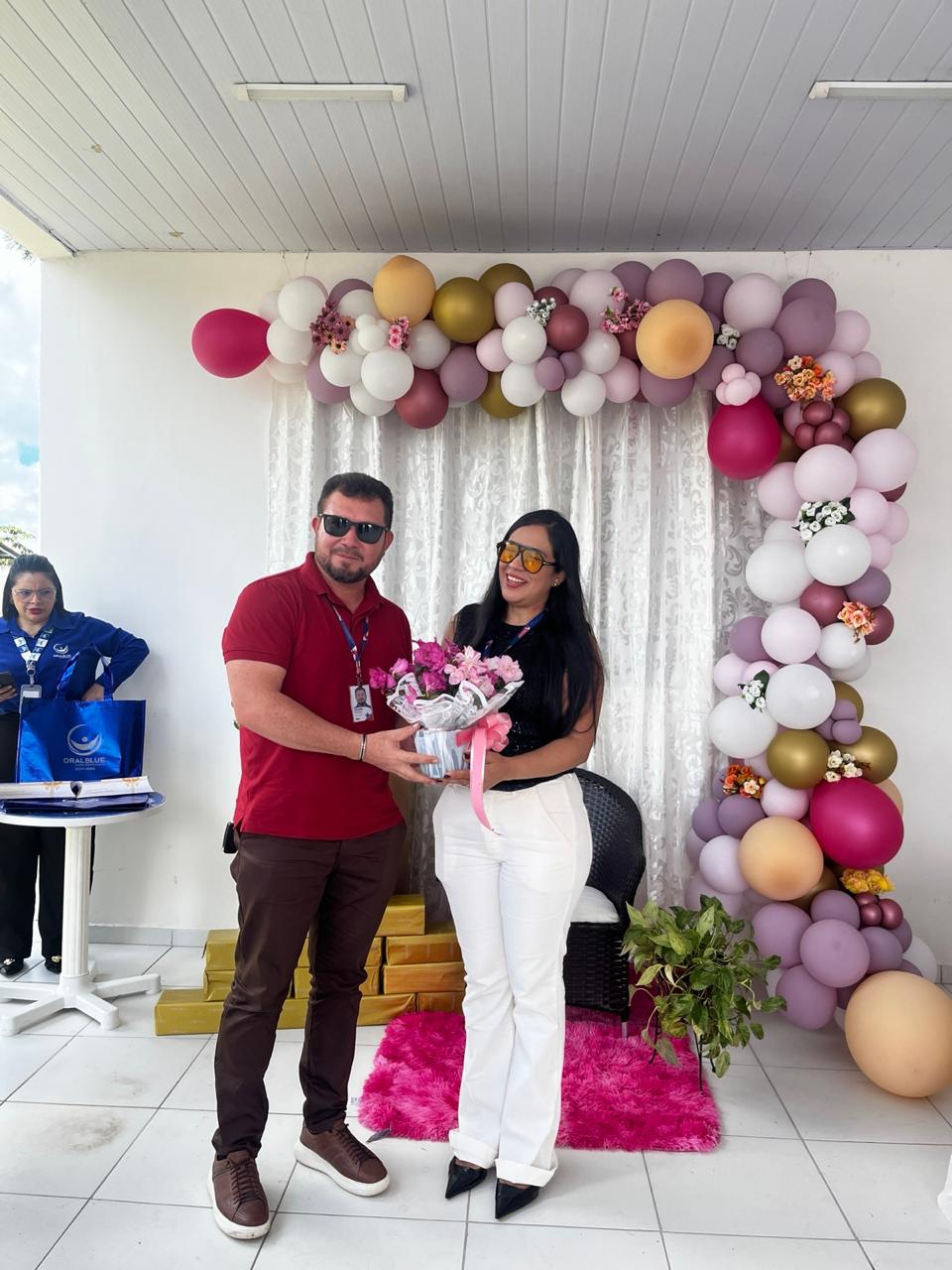 diretor entrega flores às servidoras