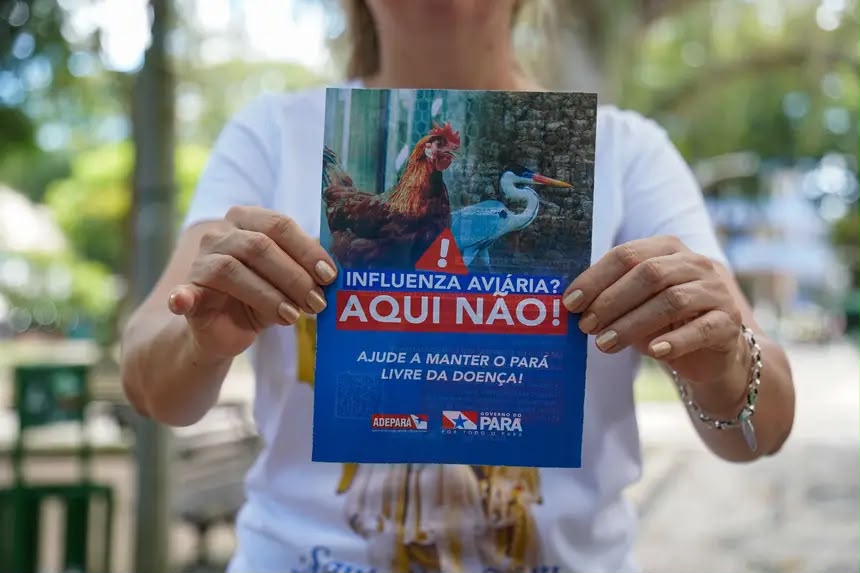 Frequentadora segurando folder de conscientização da influenza aviária